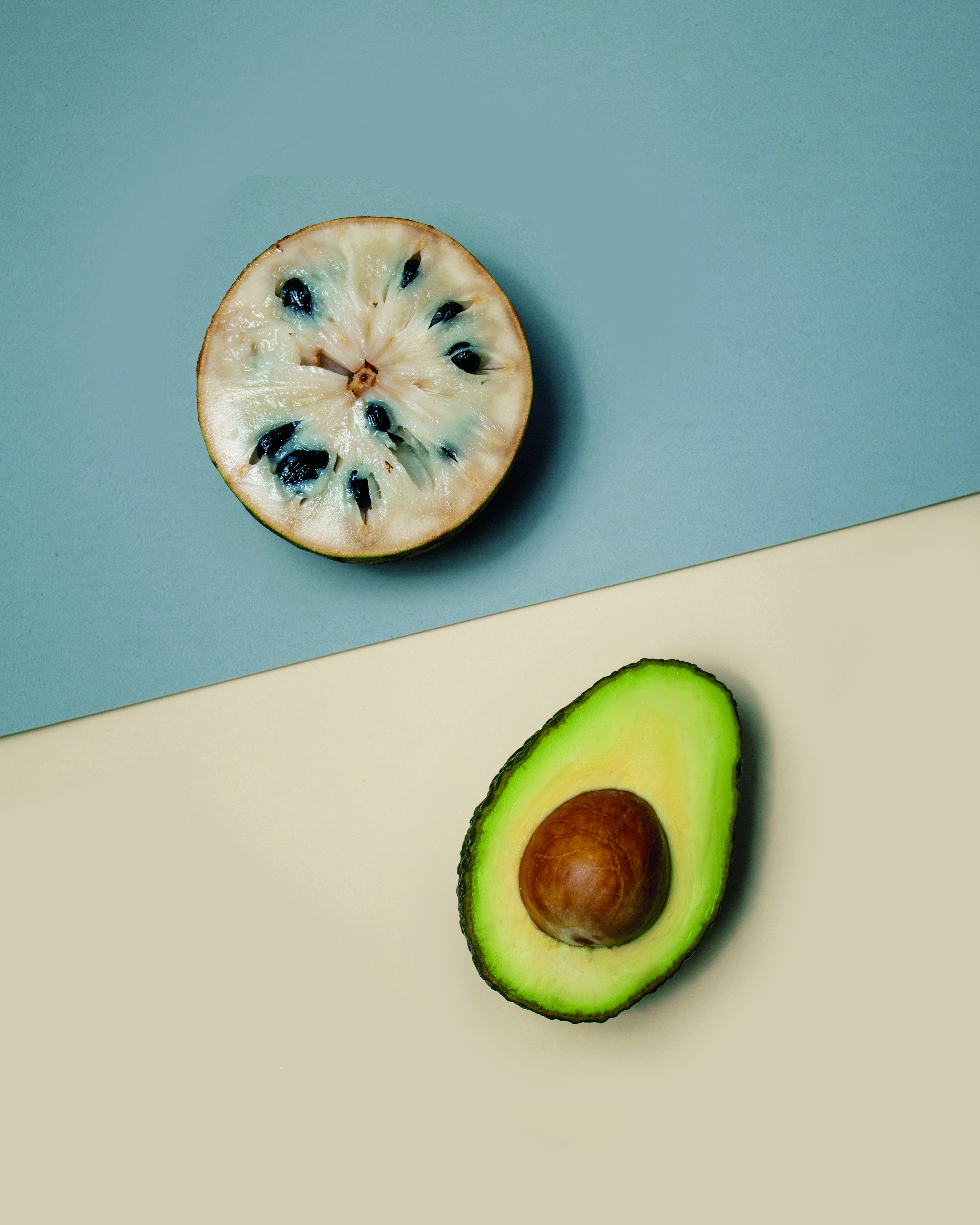 Avocados arranged with mint leaves on a pale background