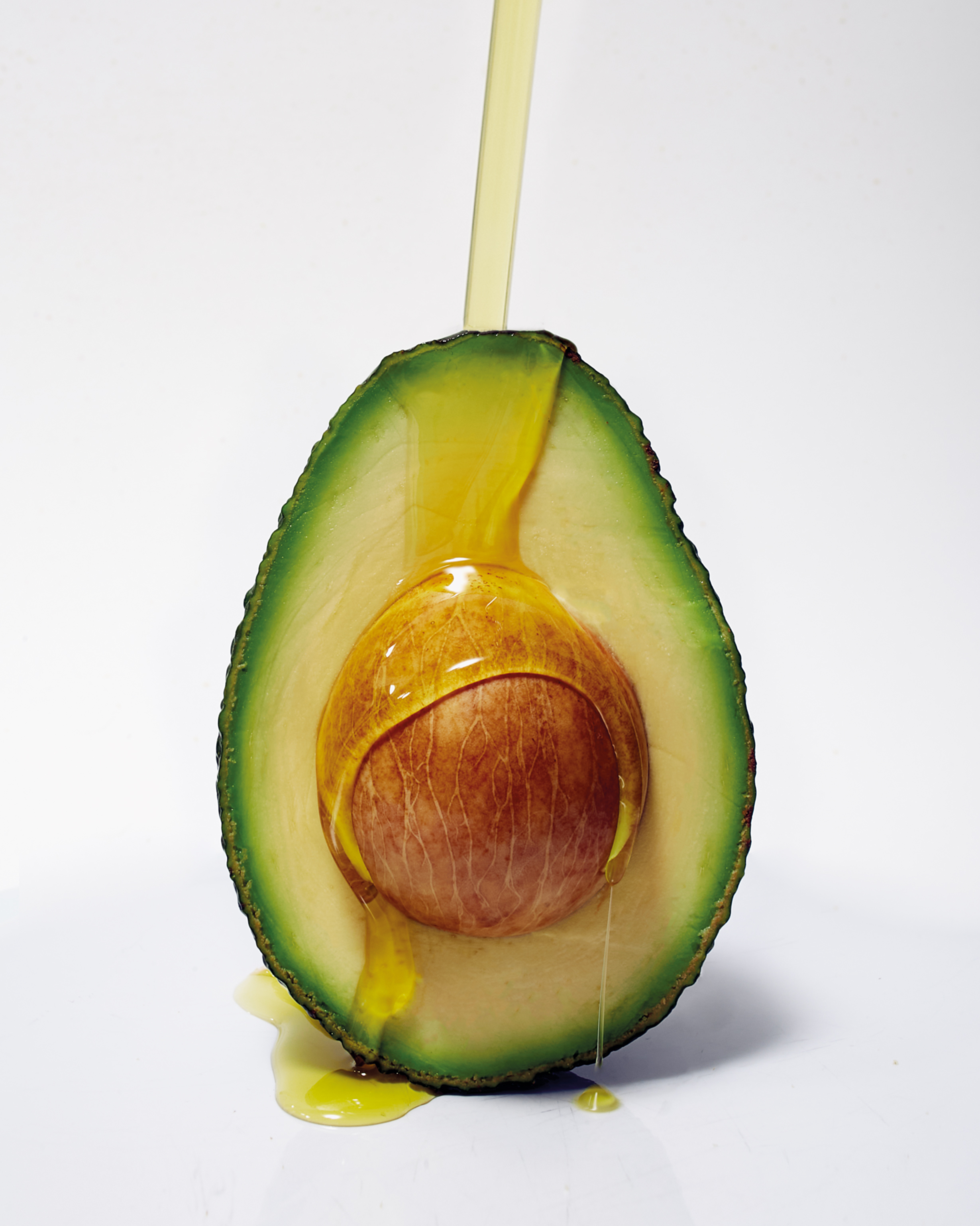 Half avocado with oil dripping