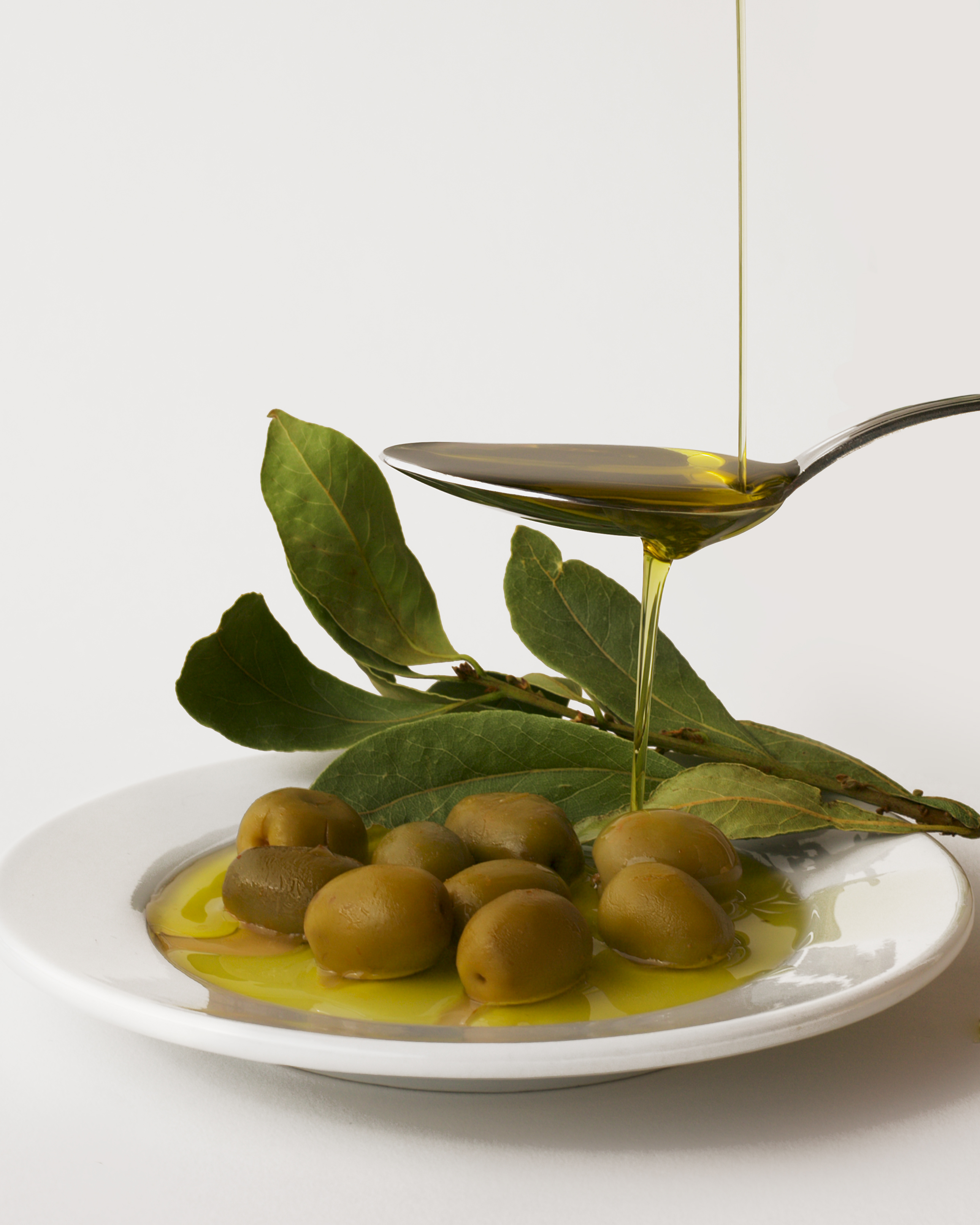 Two bottles of extra virgin olive oil resting on folded linen