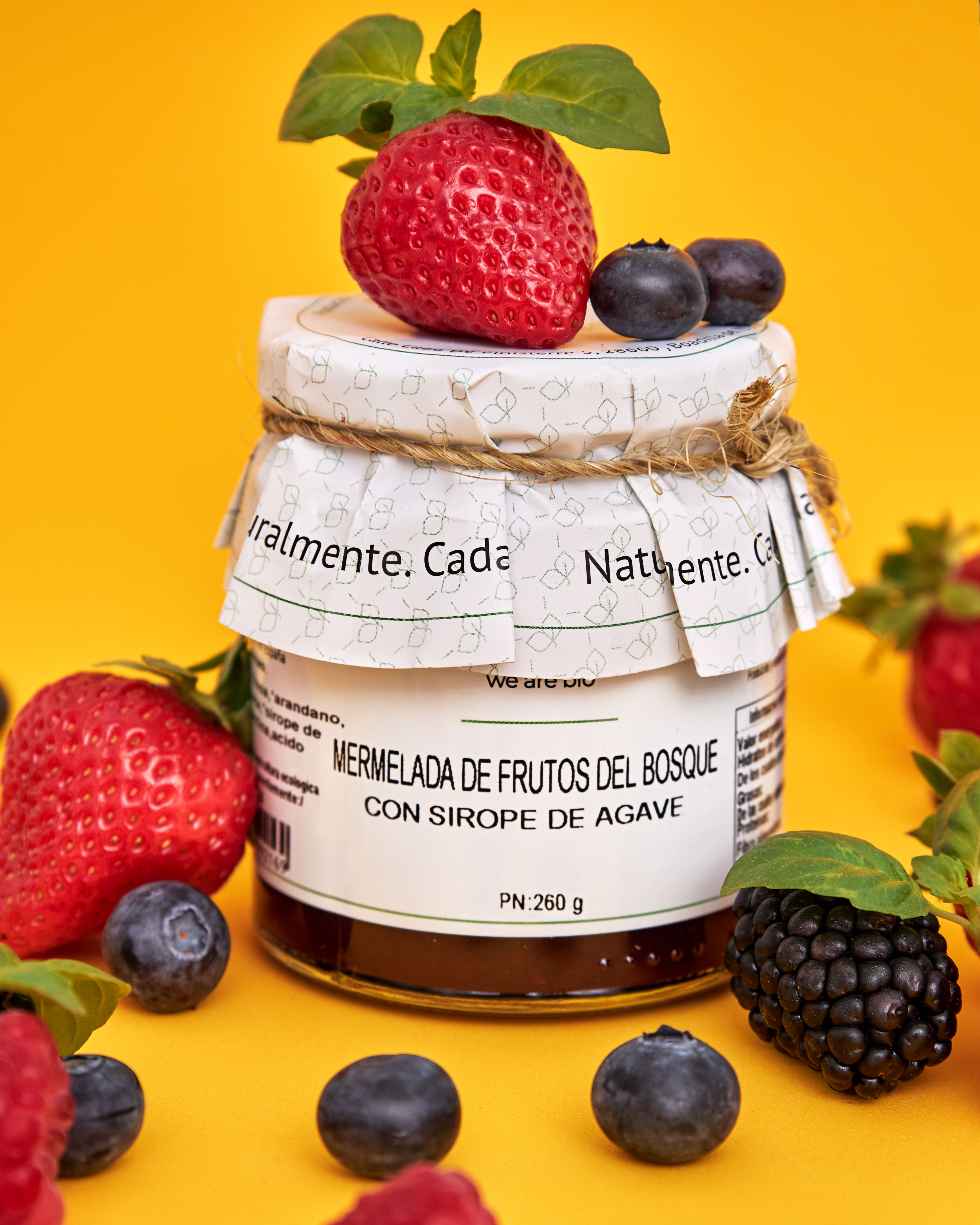 A jar of forest-berry preserve, dark and glistening, with a silver spoon